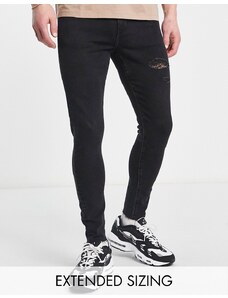 ASOS DESIGN - Jeans spray on power stretch nero slavato con abrasioni e fondo grezzo