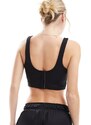 Nike Training Nike - Swoosh - Reggiseno sportivo a supporto leggero nero stile corsetto con logo